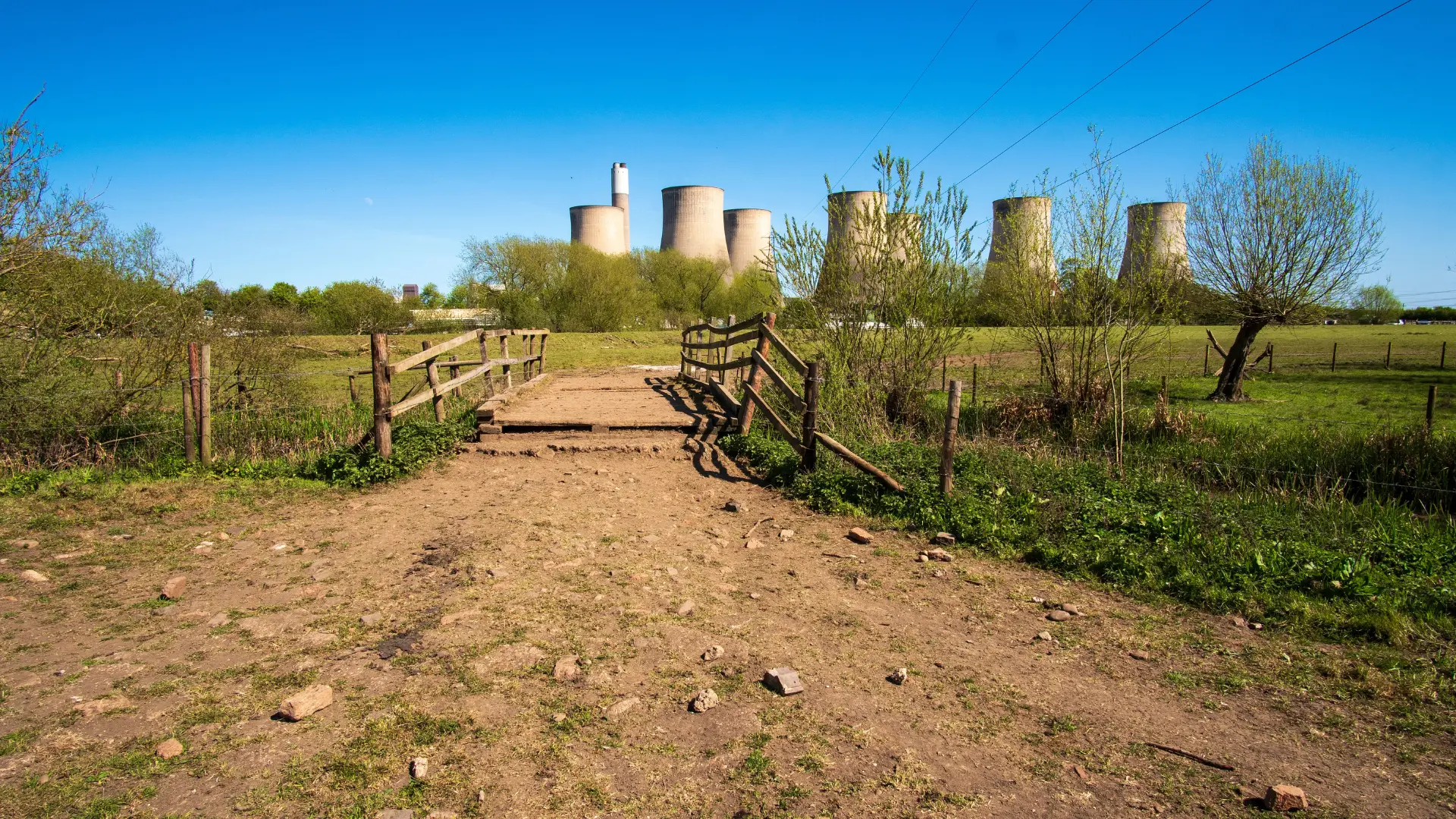Industrial site with cooling towers and power station in background requiring site security monitoring