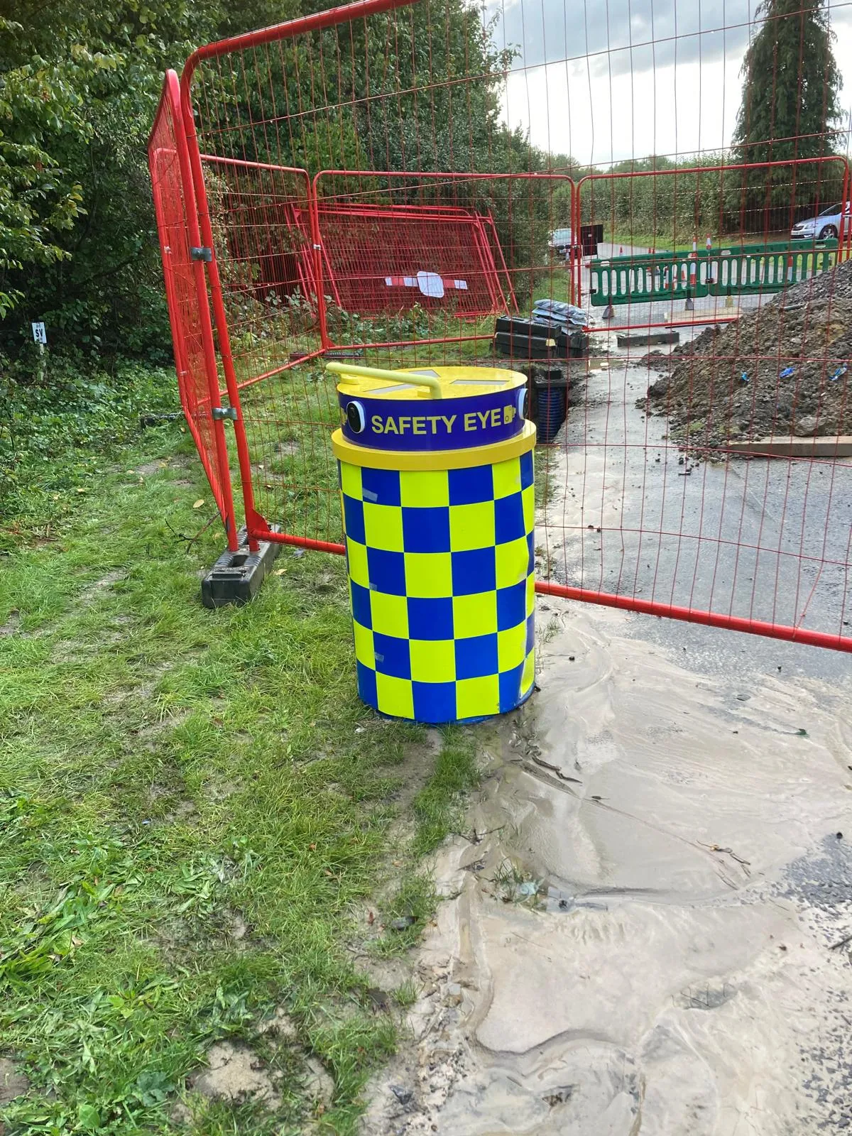 Safety Eye monitoring bollard deployed at construction site entrance with red security fencing