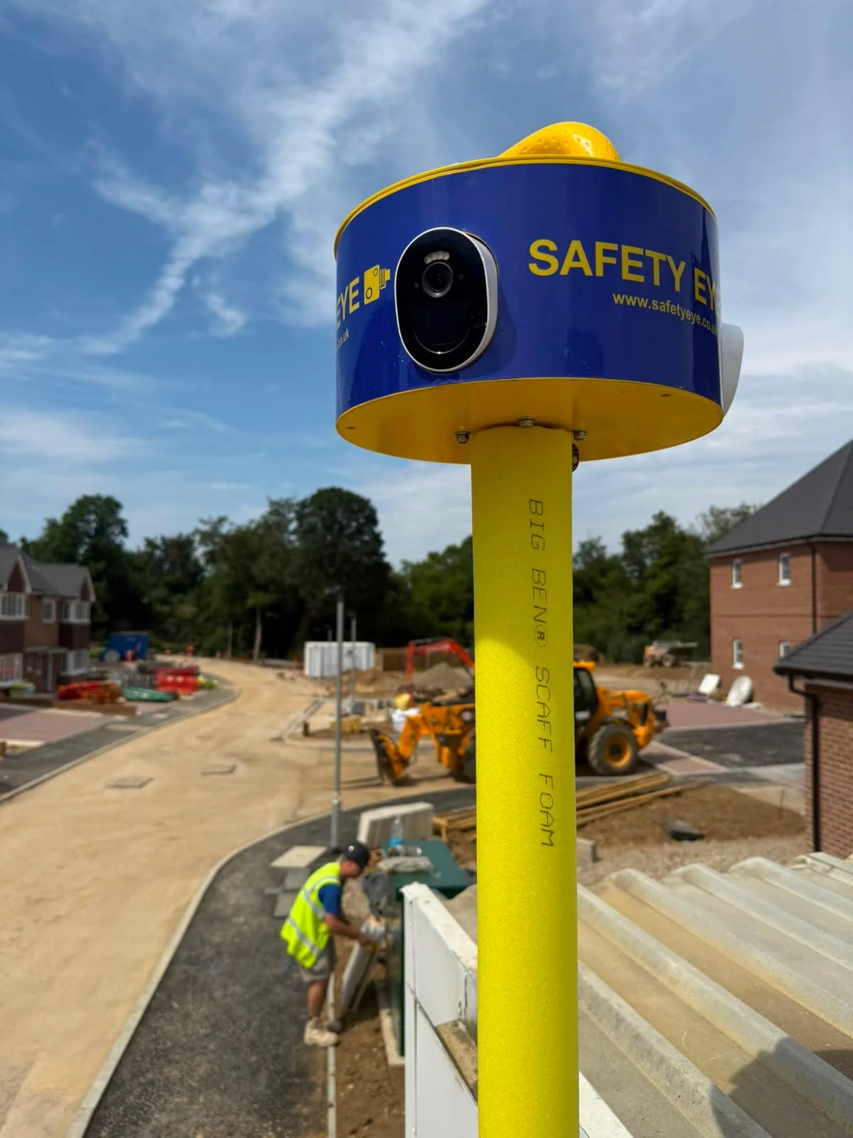 Close-up of Safety Eye camera unit at a housing development with JCB telehandler working