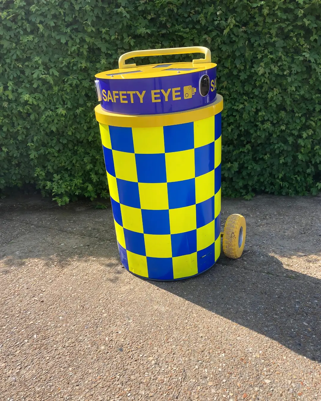 Safety Eye mobile CCTV bollard unit with blue and yellow checkered pattern on driveway